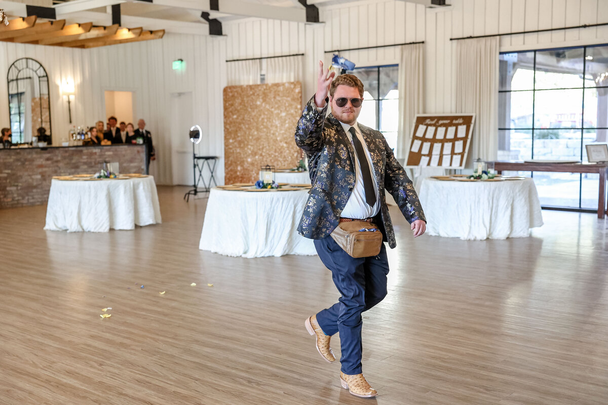 flower man tosses petals from fanny pack at Milestone Georgetown wedding in sunglasses