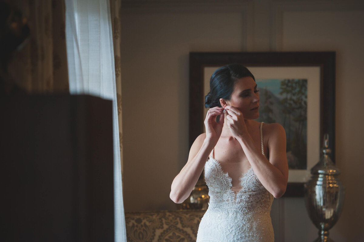 Bride putting on her jewelry before her ceremony at The Broadmoor Hotel