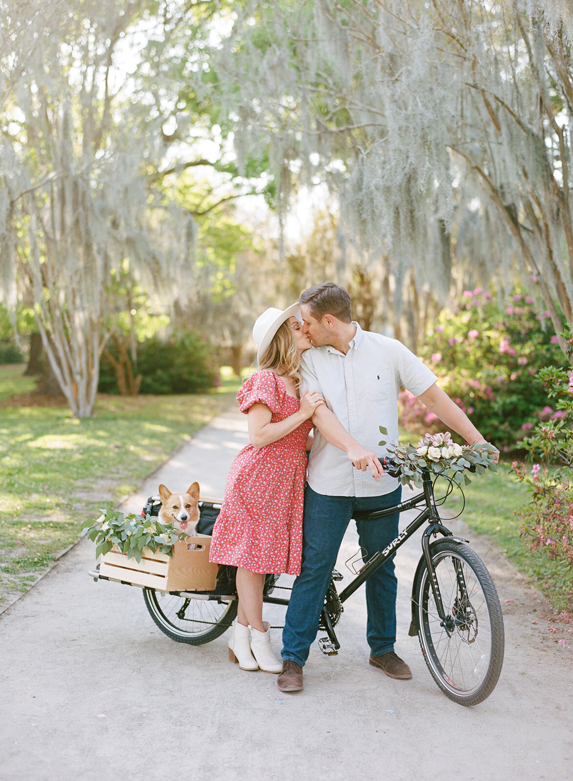 Make your engagement photos personal to you. Engagement photos in downtown Charleston at Hampton Park. This couple brought their corgi and decorated their bike in flowers.