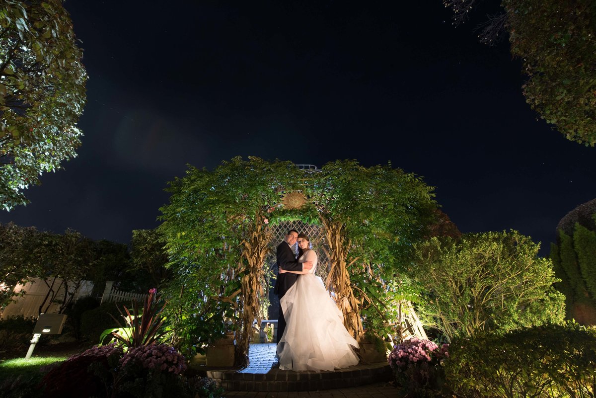 Night photo of bride and groom at the gardens at Watermill Caterers