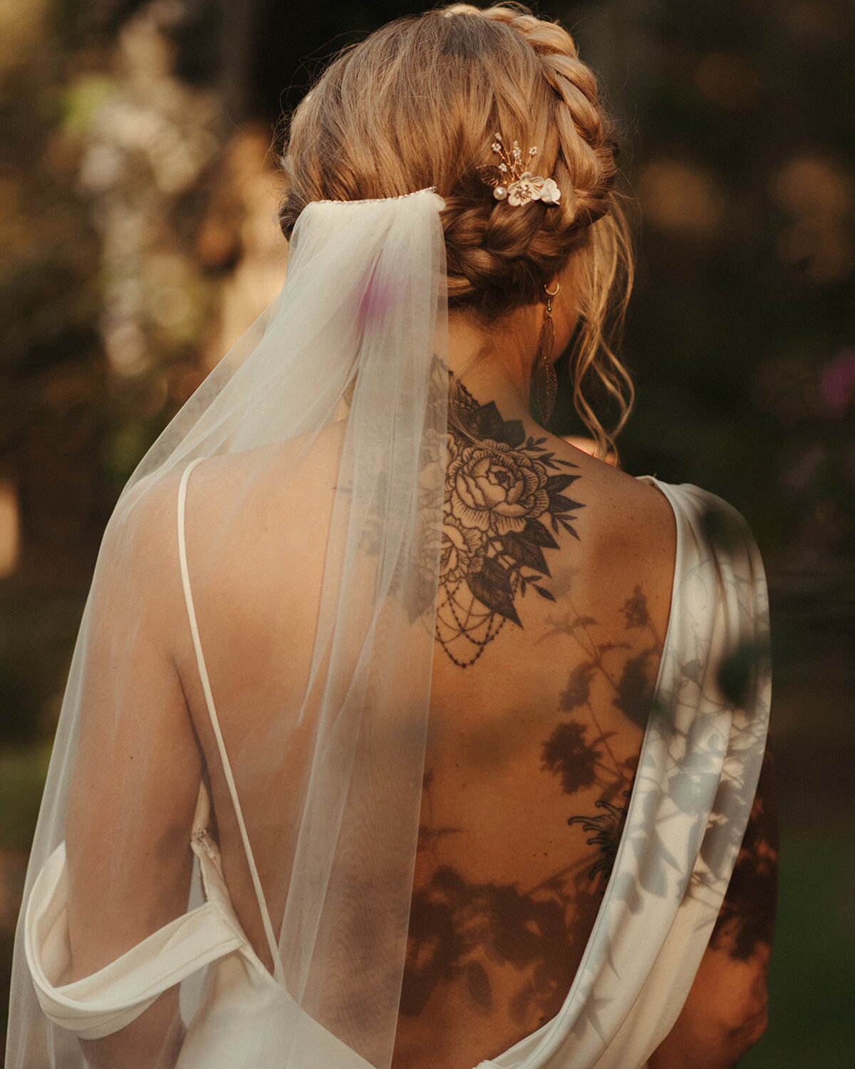 Bride wearing her hair in a braided crown with flower tattos