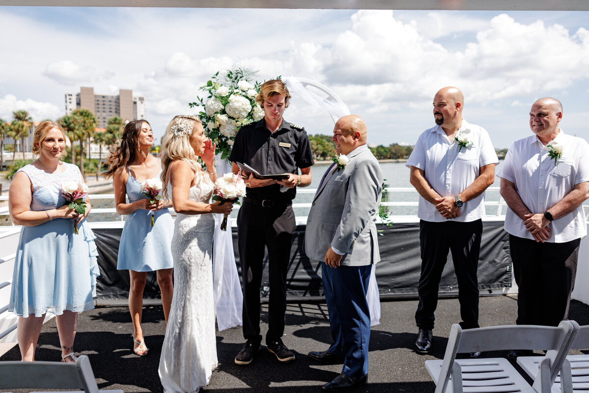 Couple exchanging vows during Florida yacht wedding ceremony with ocean backdrop.