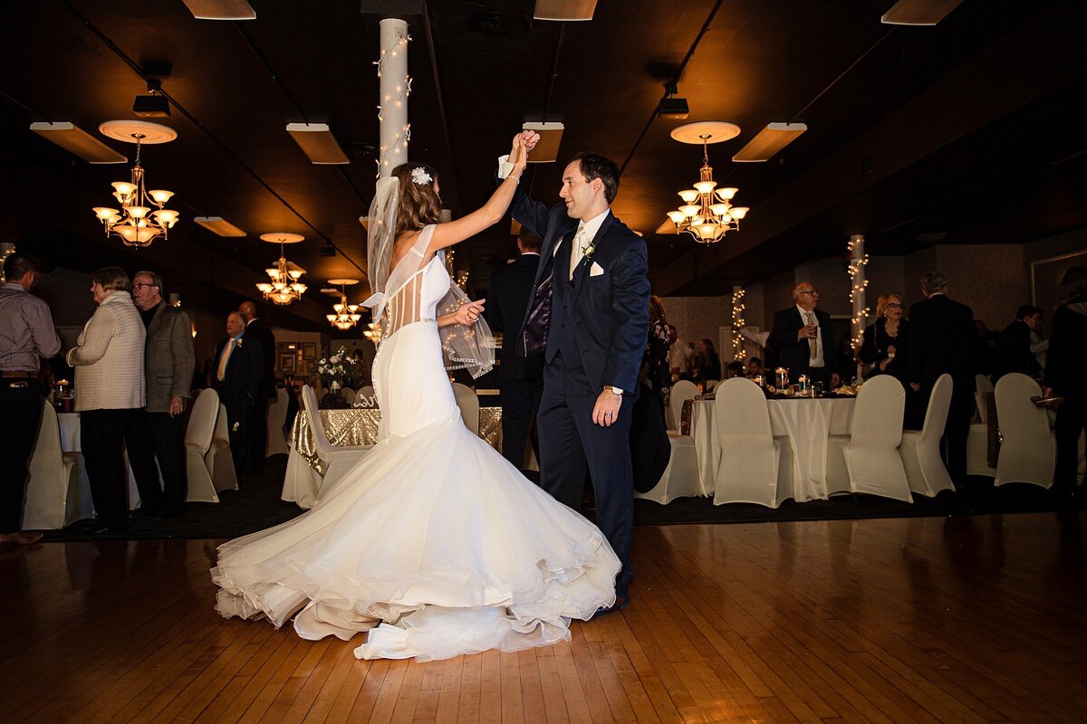 bride and groom dance at reception with gown train spinning