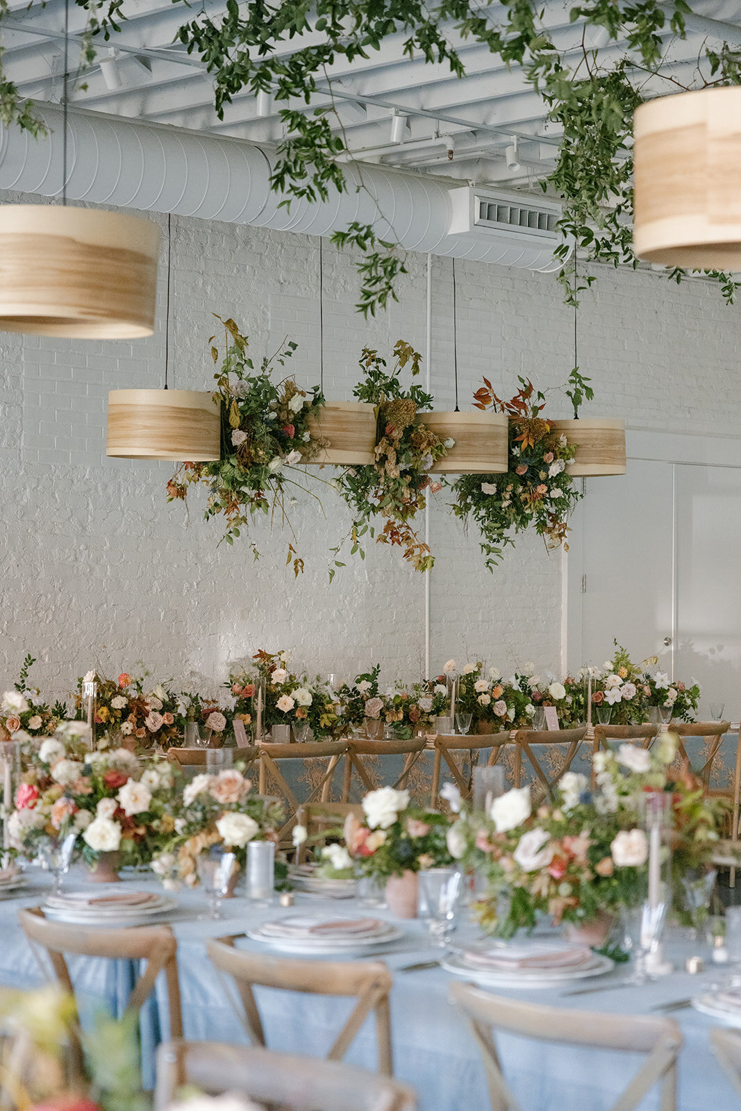 Floral Chandelier hanging floral clouds accent fall wedding reception in Raleigh, NC with roses, hydrangeas, and fall branches in colors of mauve, copper, cream, dusty pink, and green. Design by Rosemary and Finch Floral Design in Nashville, TN.