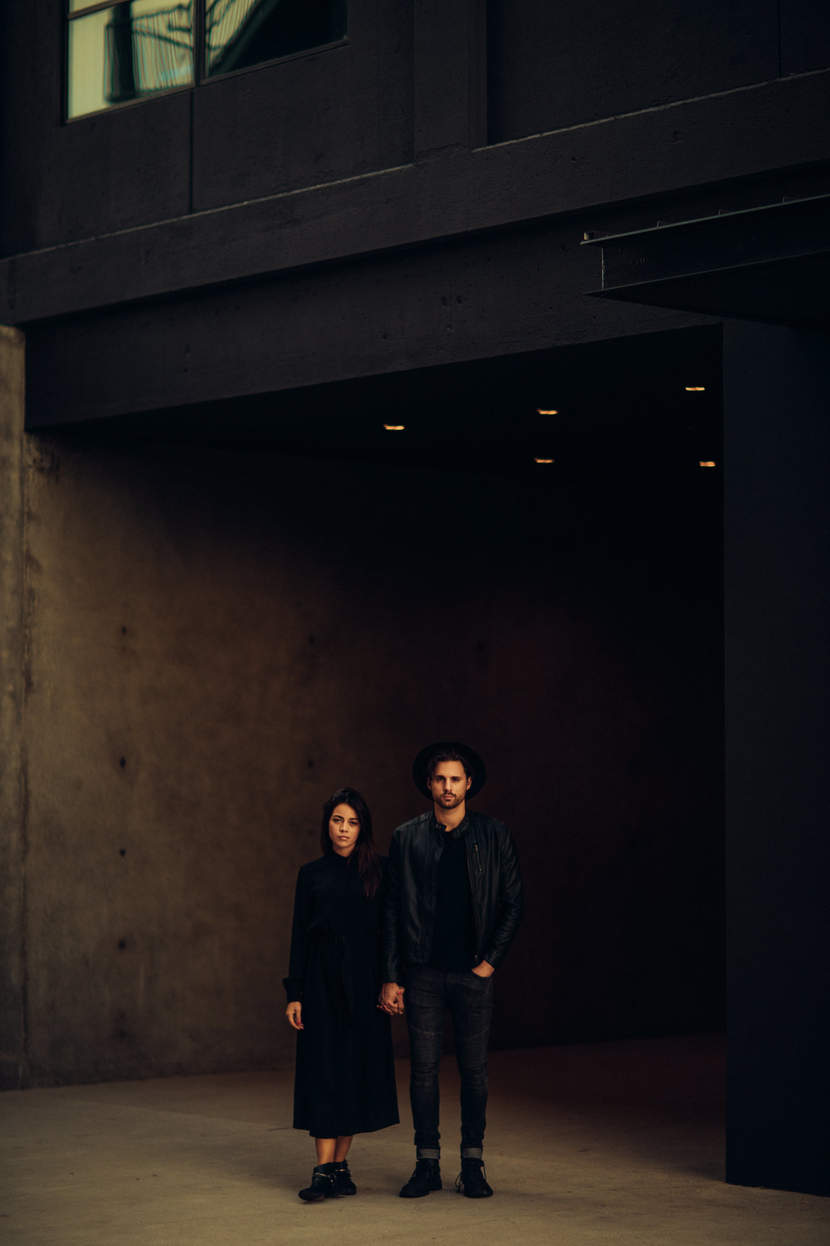 Engagement Photography Of Couple Holding Hands Under Building