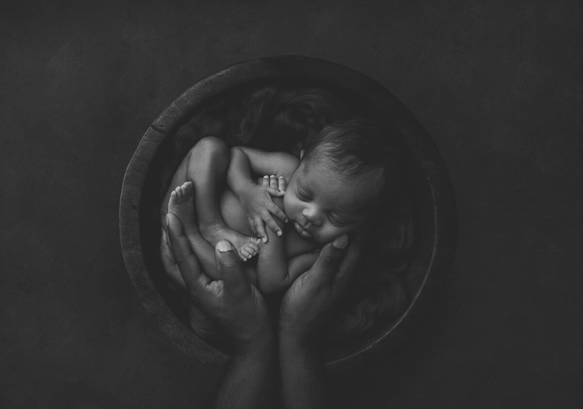 a baby in a wood basket with a darker photo theme