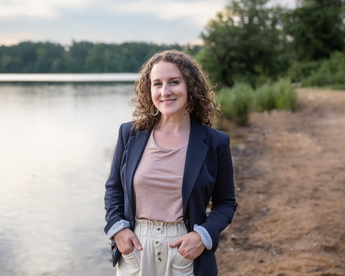 An entrepreneur smiles for a headshot near a Baltimore, Maryland lake.