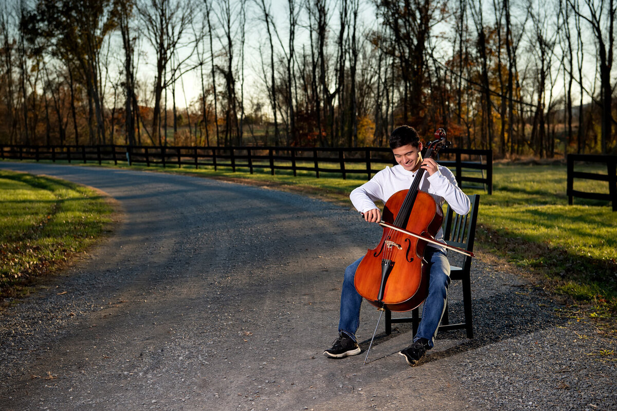 senior boy with cello in road