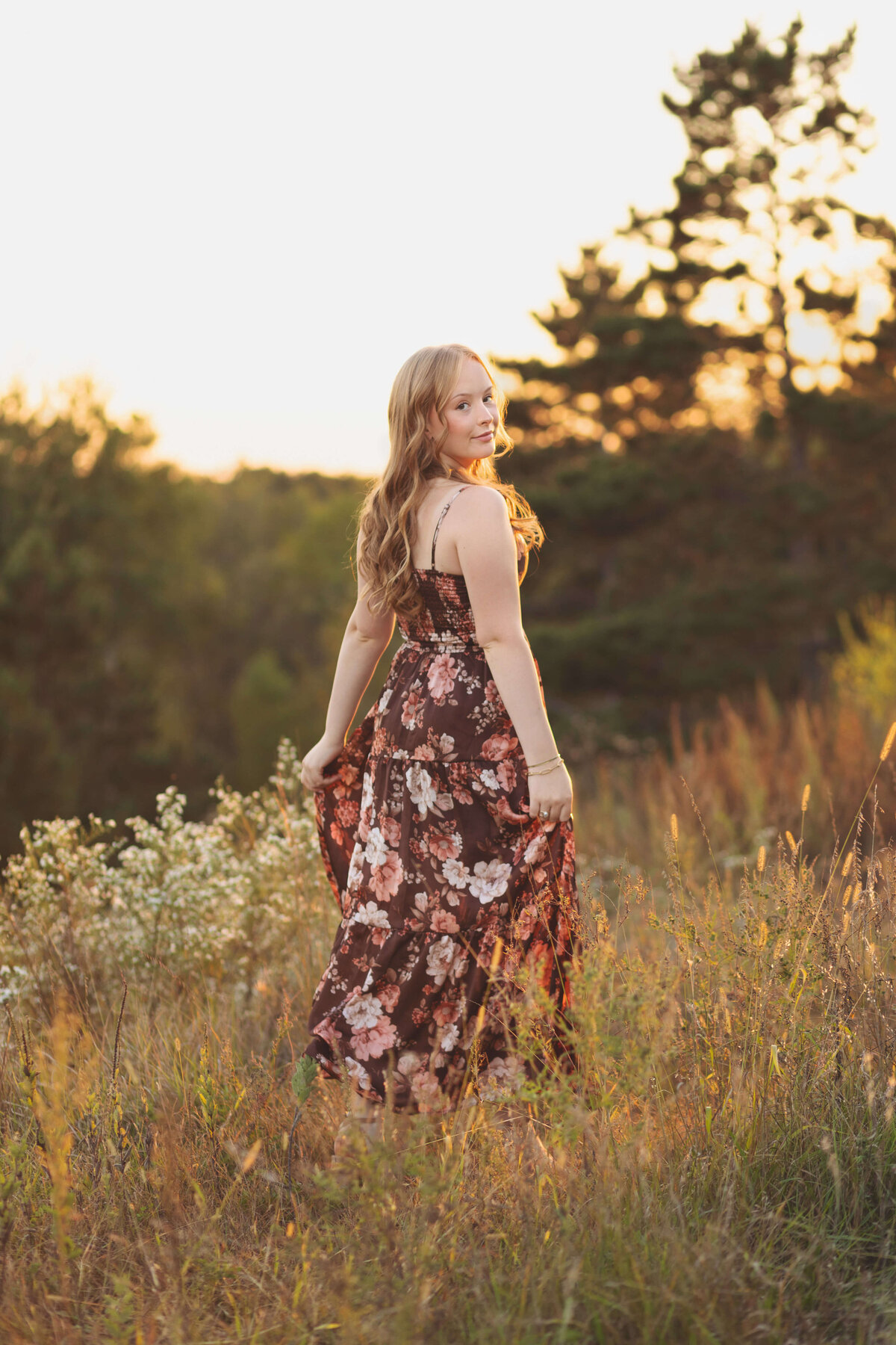 girl looking over shoulder in nature at sunset