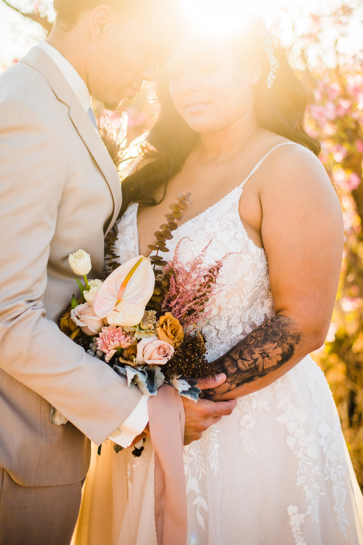 Bride and Groom holding each other close up sun flare bouquet wedding Schnepf Farms Meadows cherry blossoms