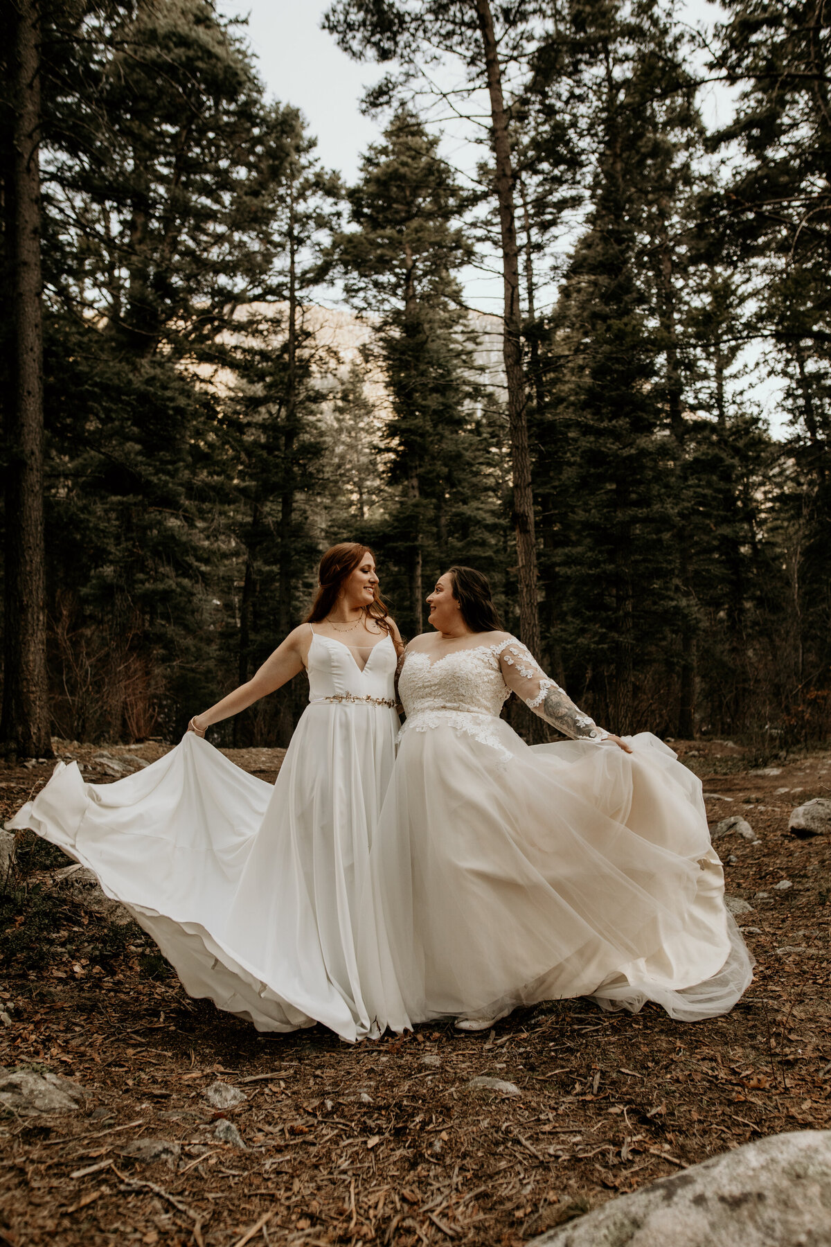 same sex couple females spinning gowns together
