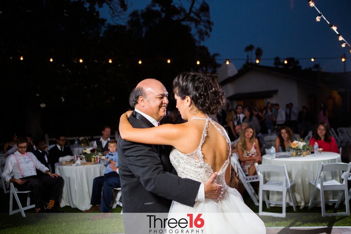 Bride dances with her father at her wedding reception under the starry night