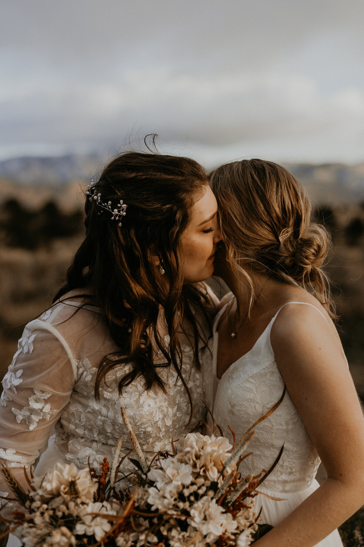 Two newlywed brides holding each other