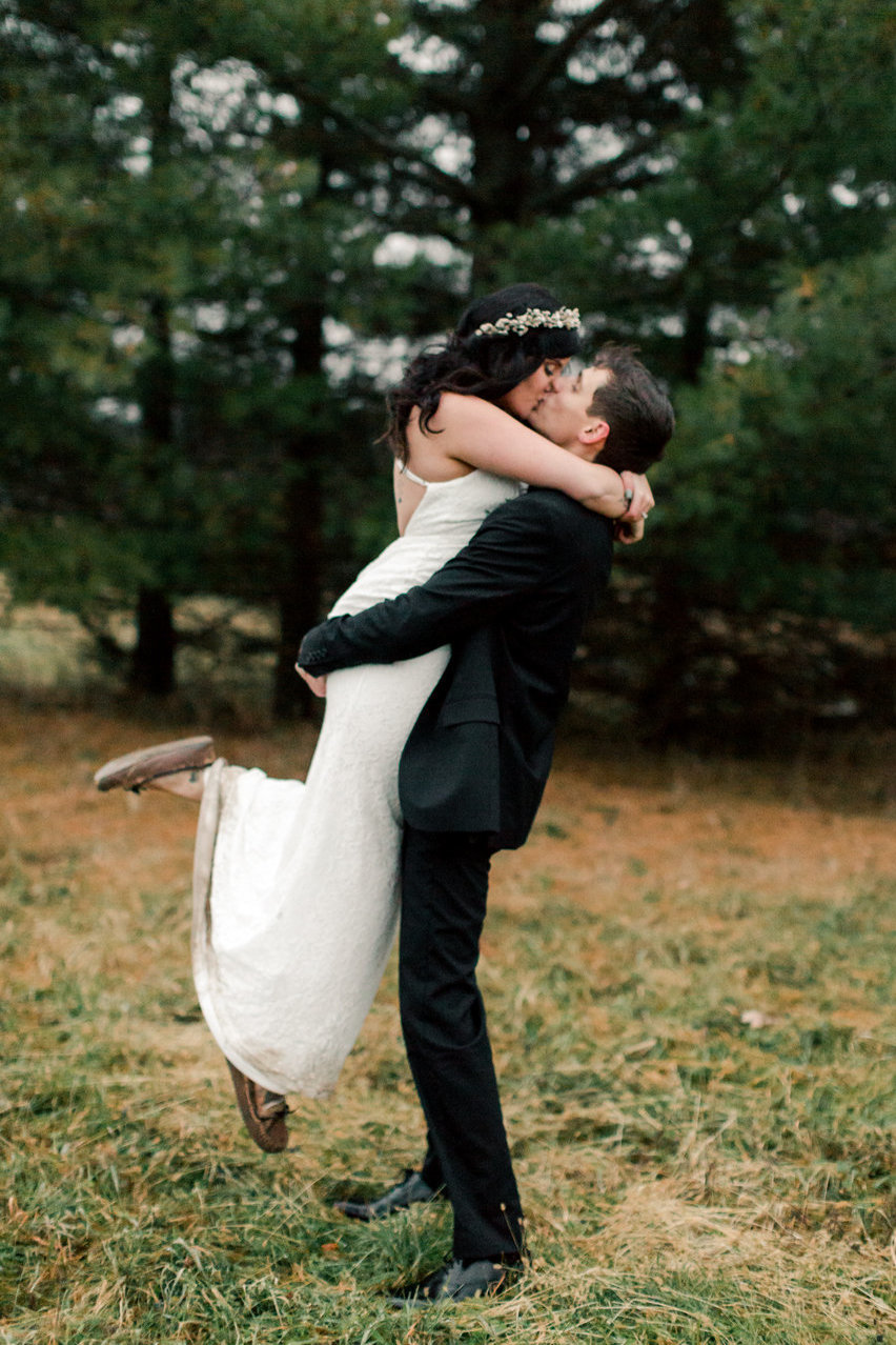 casual fall elopement in rochester minnesota pines and bride and groom kiss outdoors