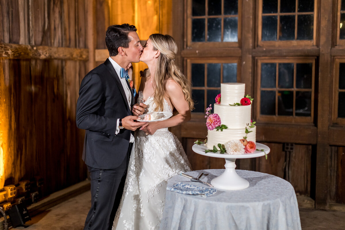 Couple Kissing by cake at the Barn on the Preserve