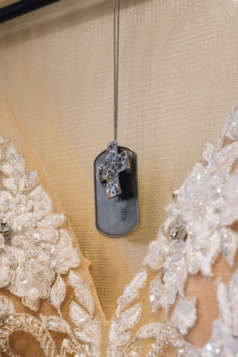 military dog tags hanging with wedding dress