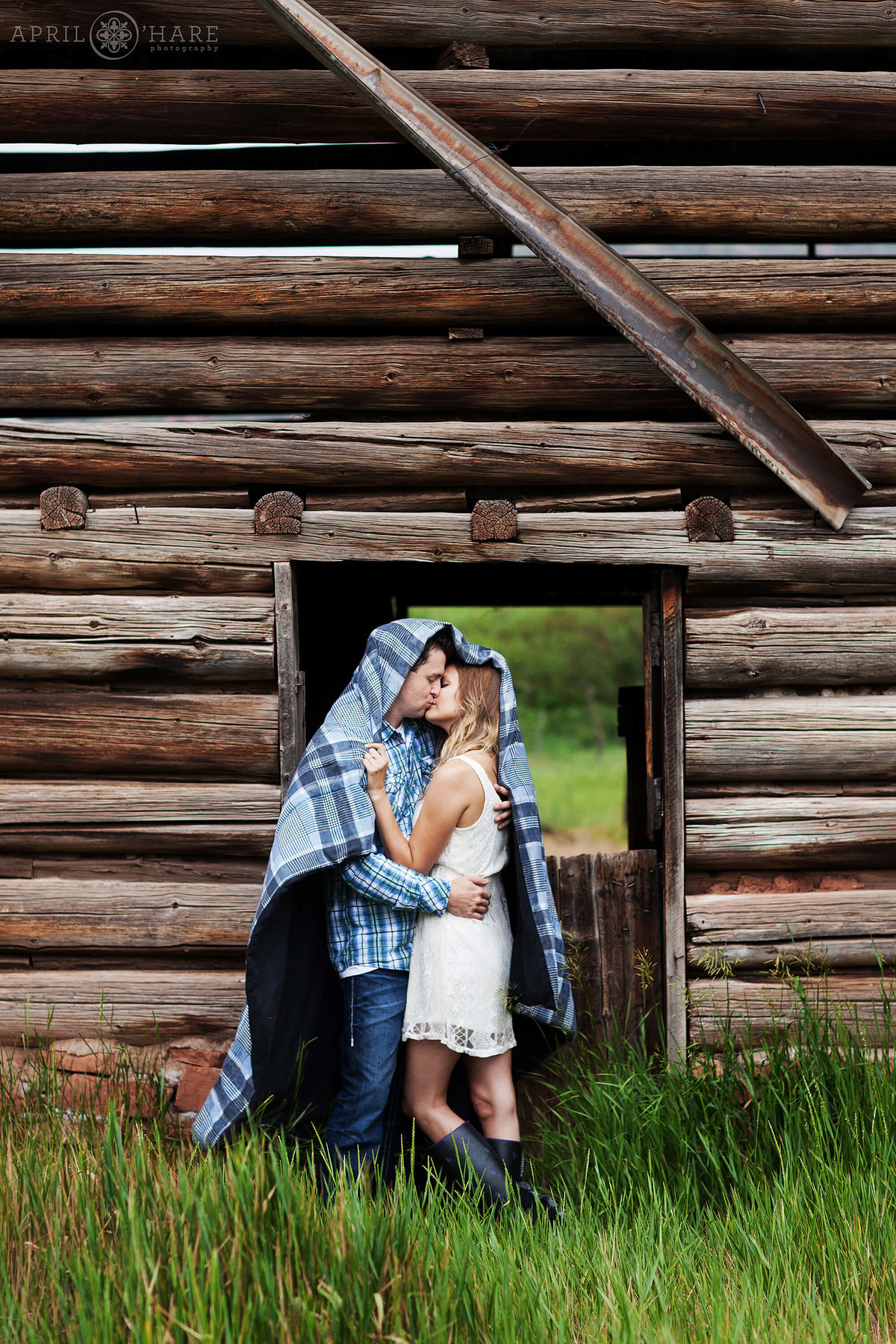Cuddling under a blanket at a rustic barn engagement photography at Sylvan Lake State Park Eagle CO