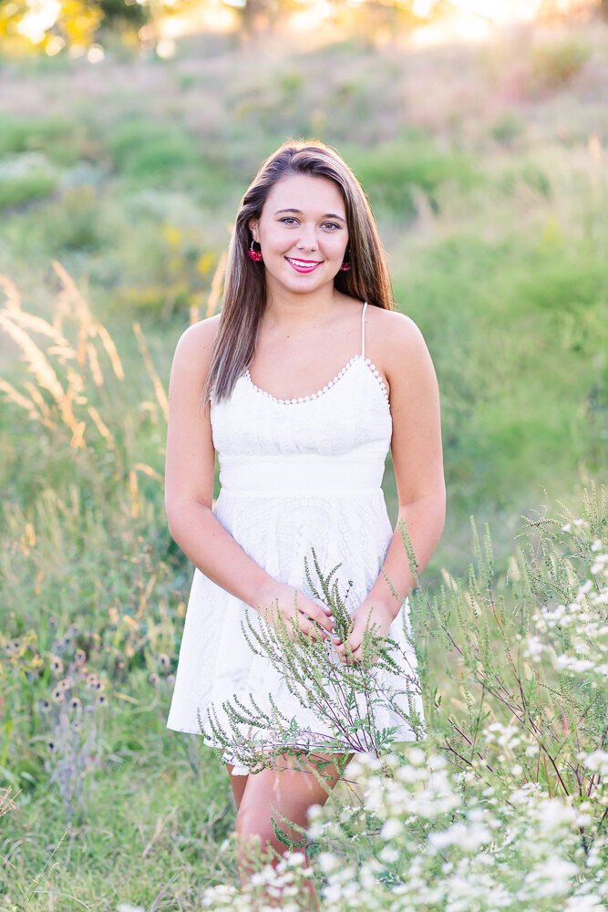Bright and airy golden hour senior photo session in a field.