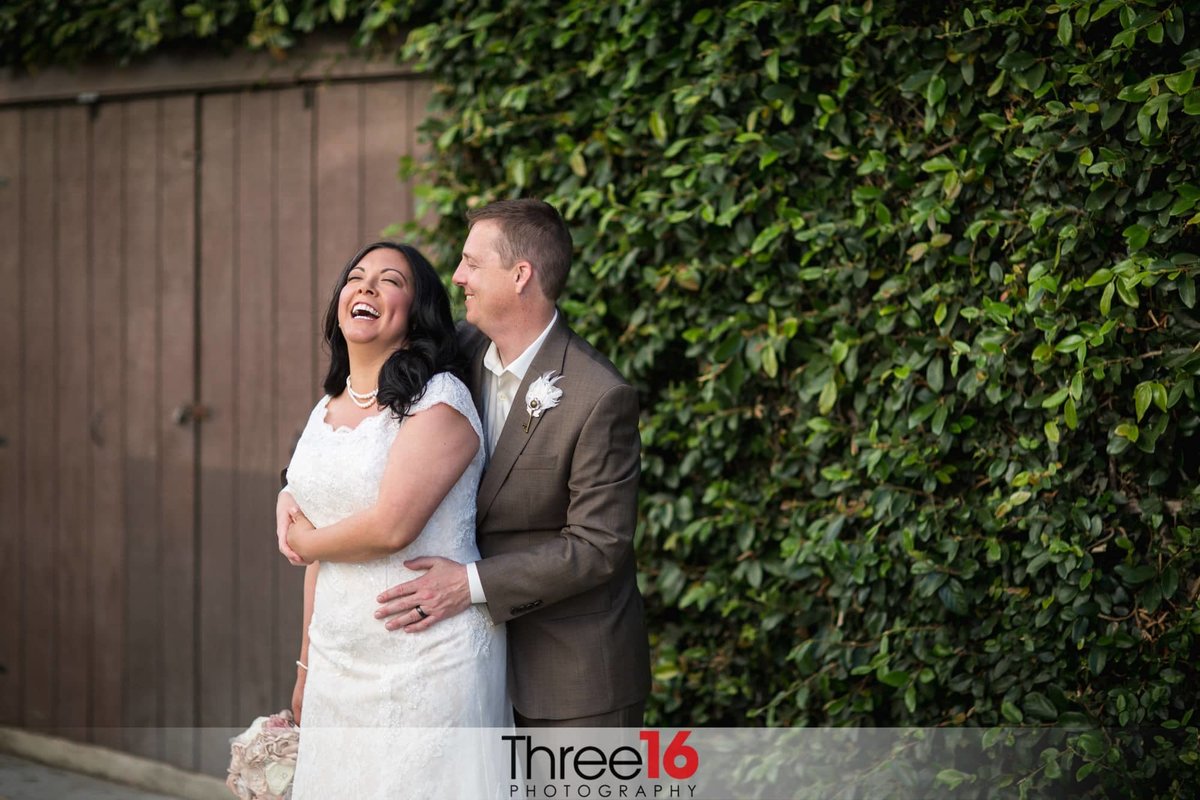 Groom makes his Bride laugh during photo session