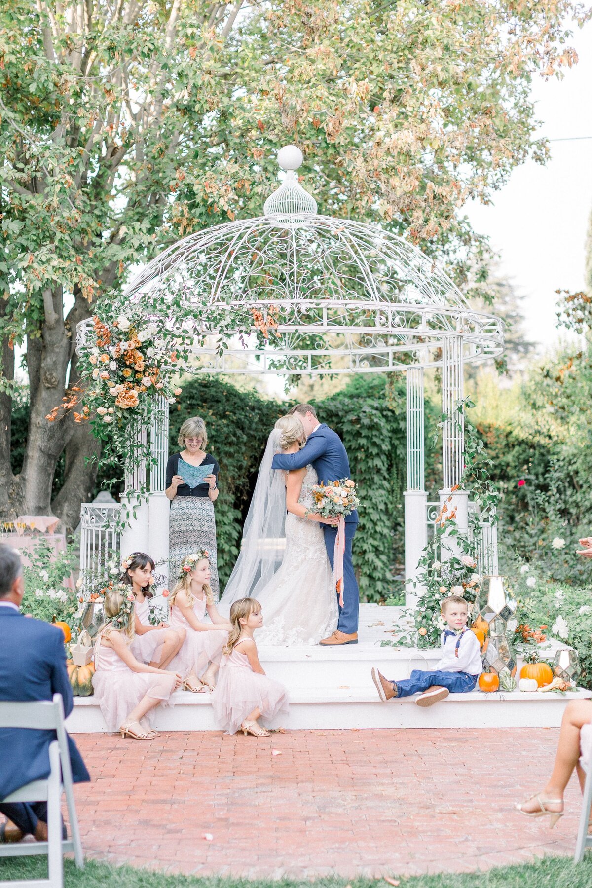 This wedding arbor is full of flowers and greenery.