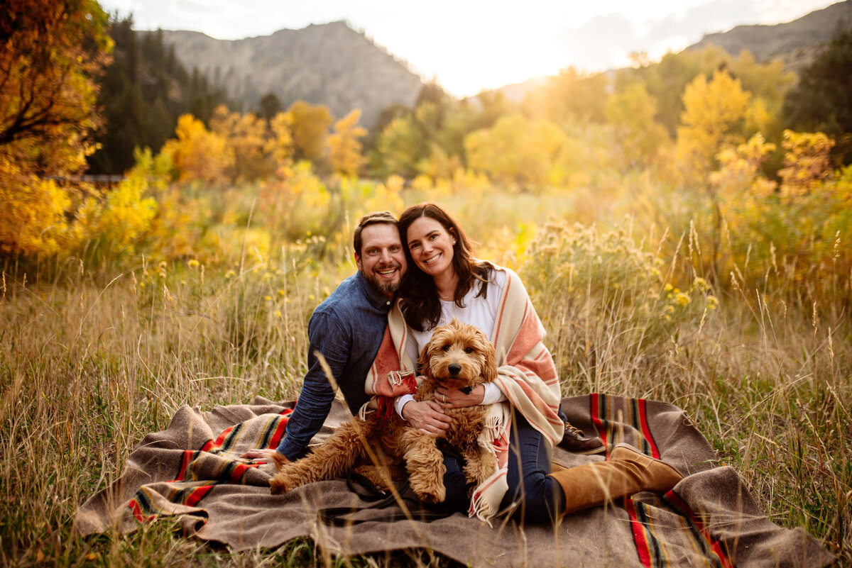 cute couple on picnic blanket in field with their dog for blogger photoshoot