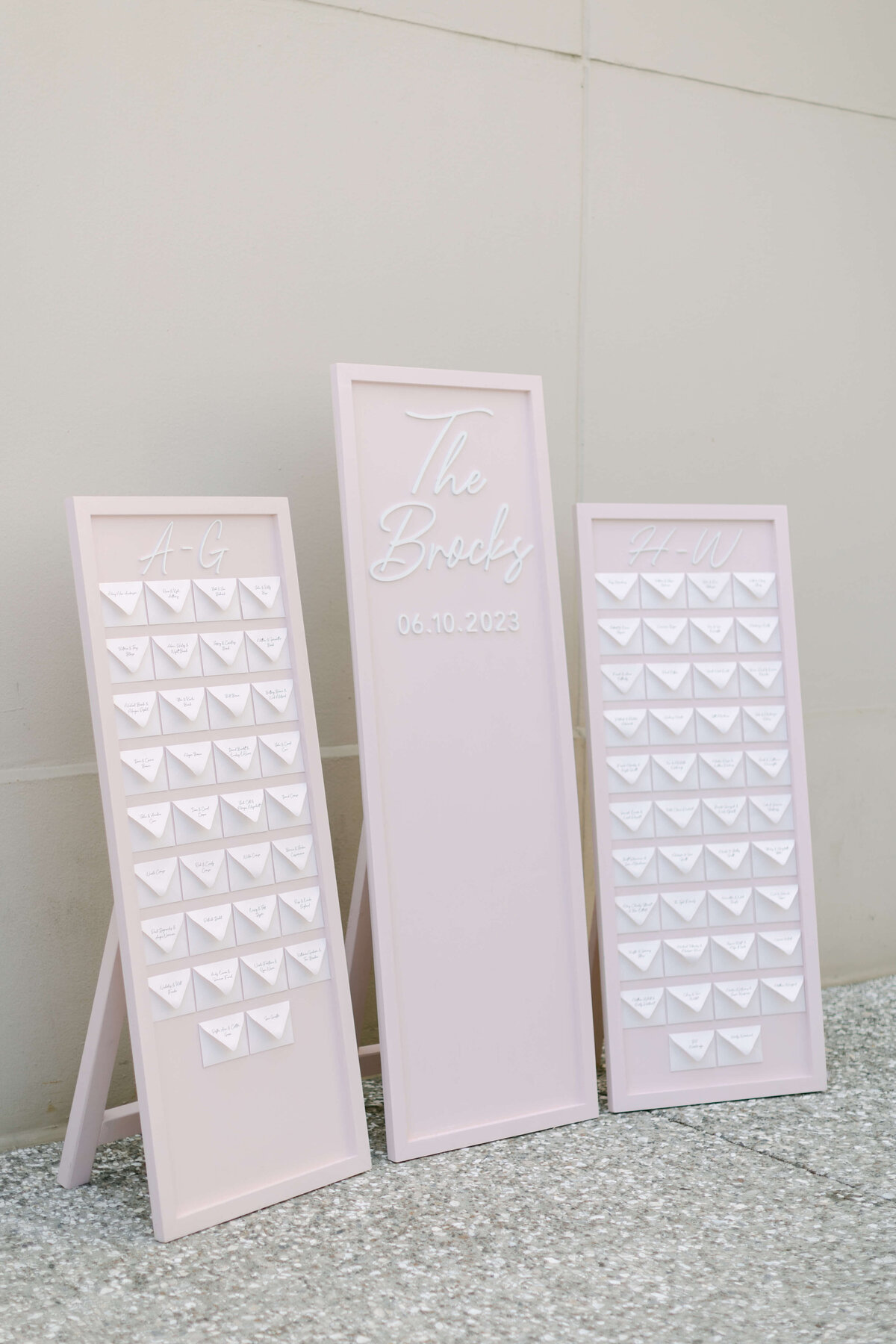 Guest cards sitting on a pink wall.