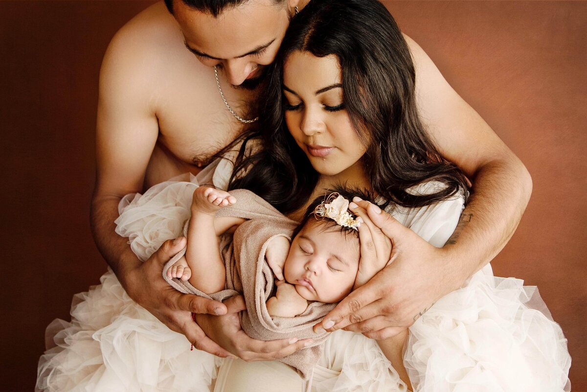 st-louis-newborn-photographer-mom-and-dad-holding-baby-girl-in-ruffle-robe