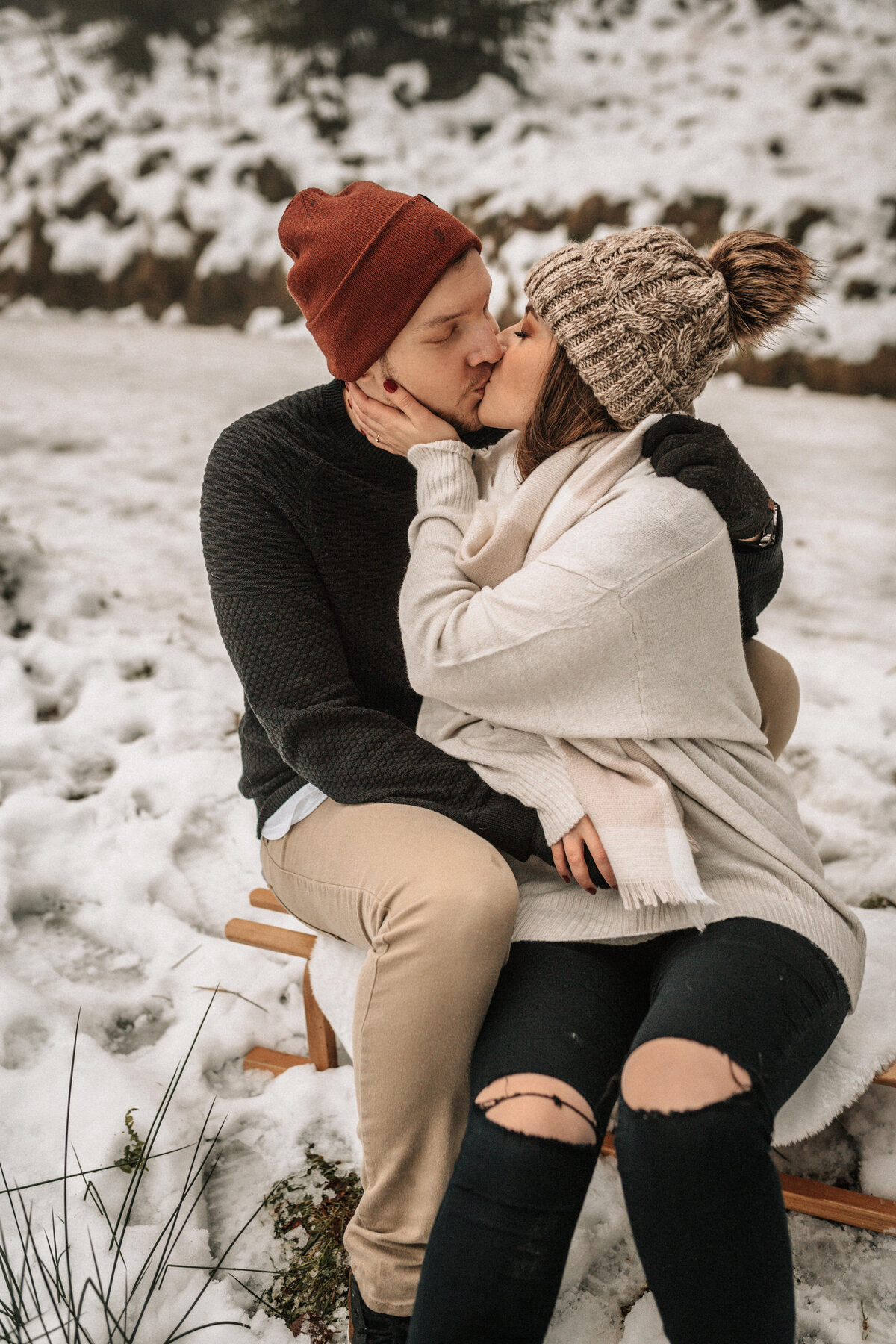 Liebespaar auf einem Schlitten im Schnee