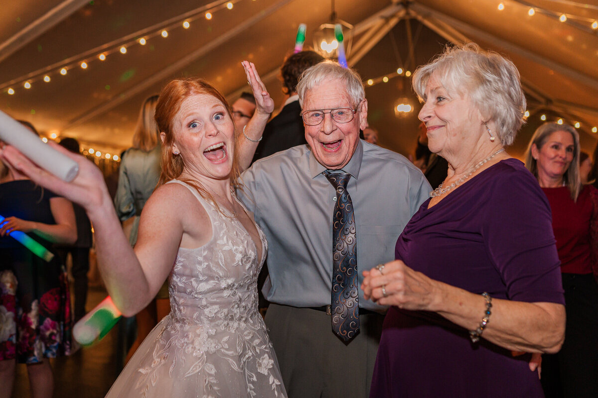 A bride dancing with her grandparents at her wedding reception