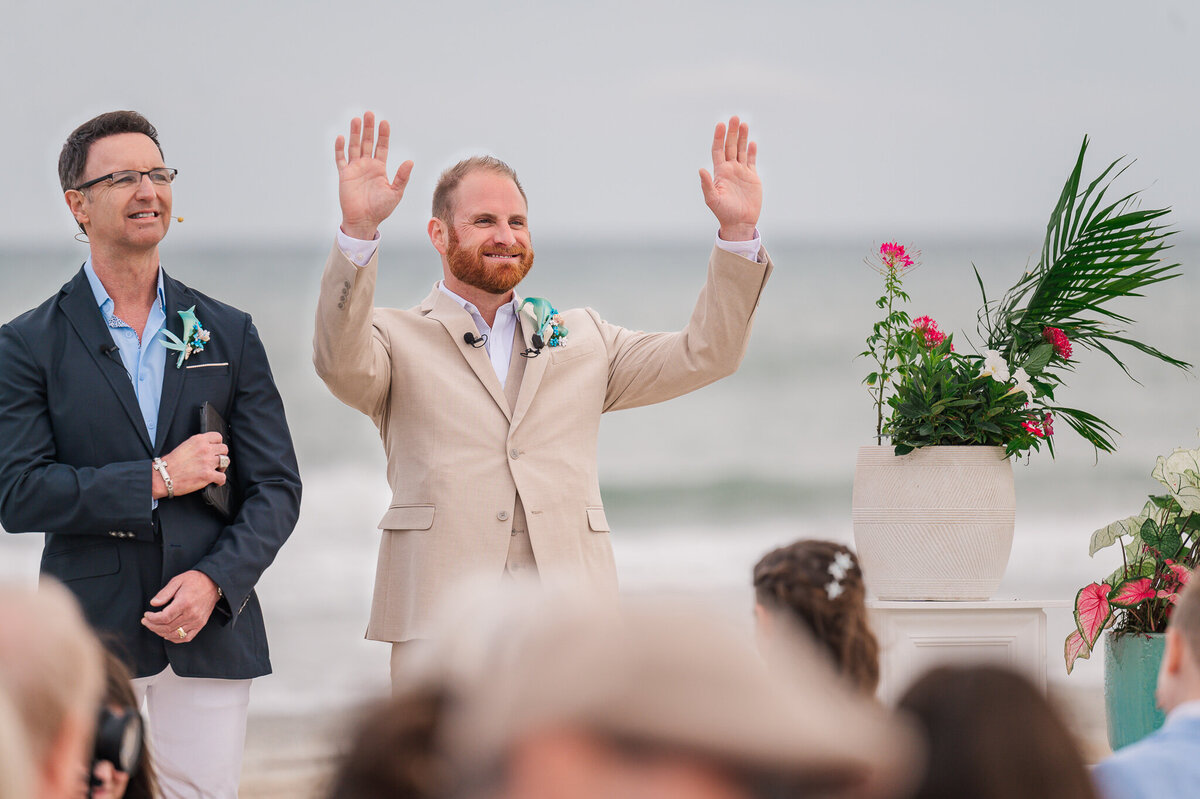 An ecstatic groom during a first look as his bride walks down the aisle on their wedding day as he enjoys his Raleigh wedding photos 