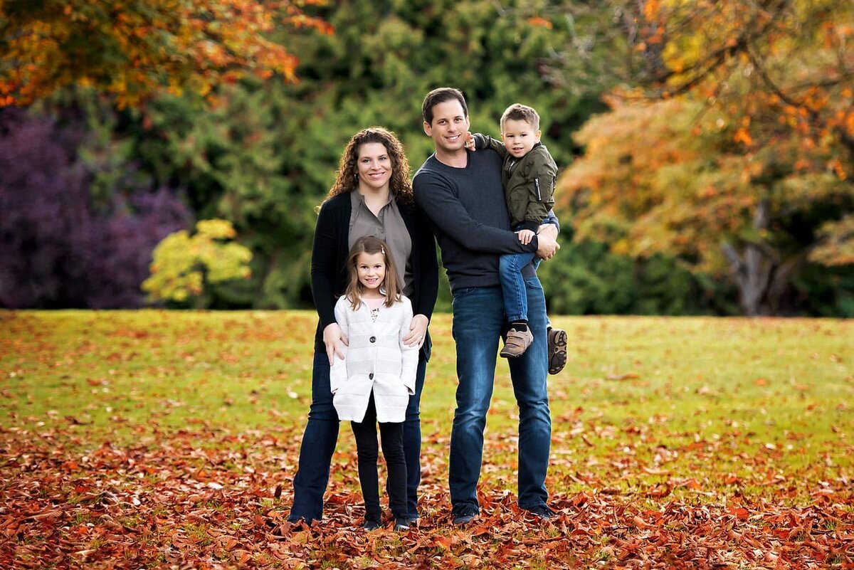 Family of 4 with mother, father, daughter and son posing for classic fall photos in Vancouver