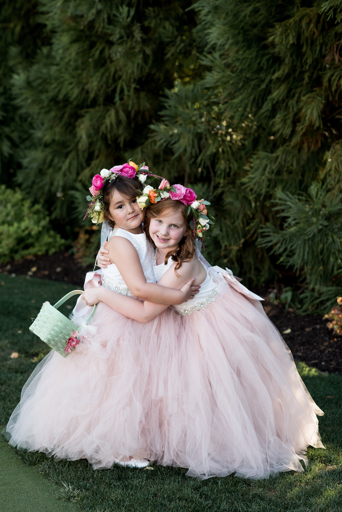 Flower girls with pink dresses and pink floral crowns