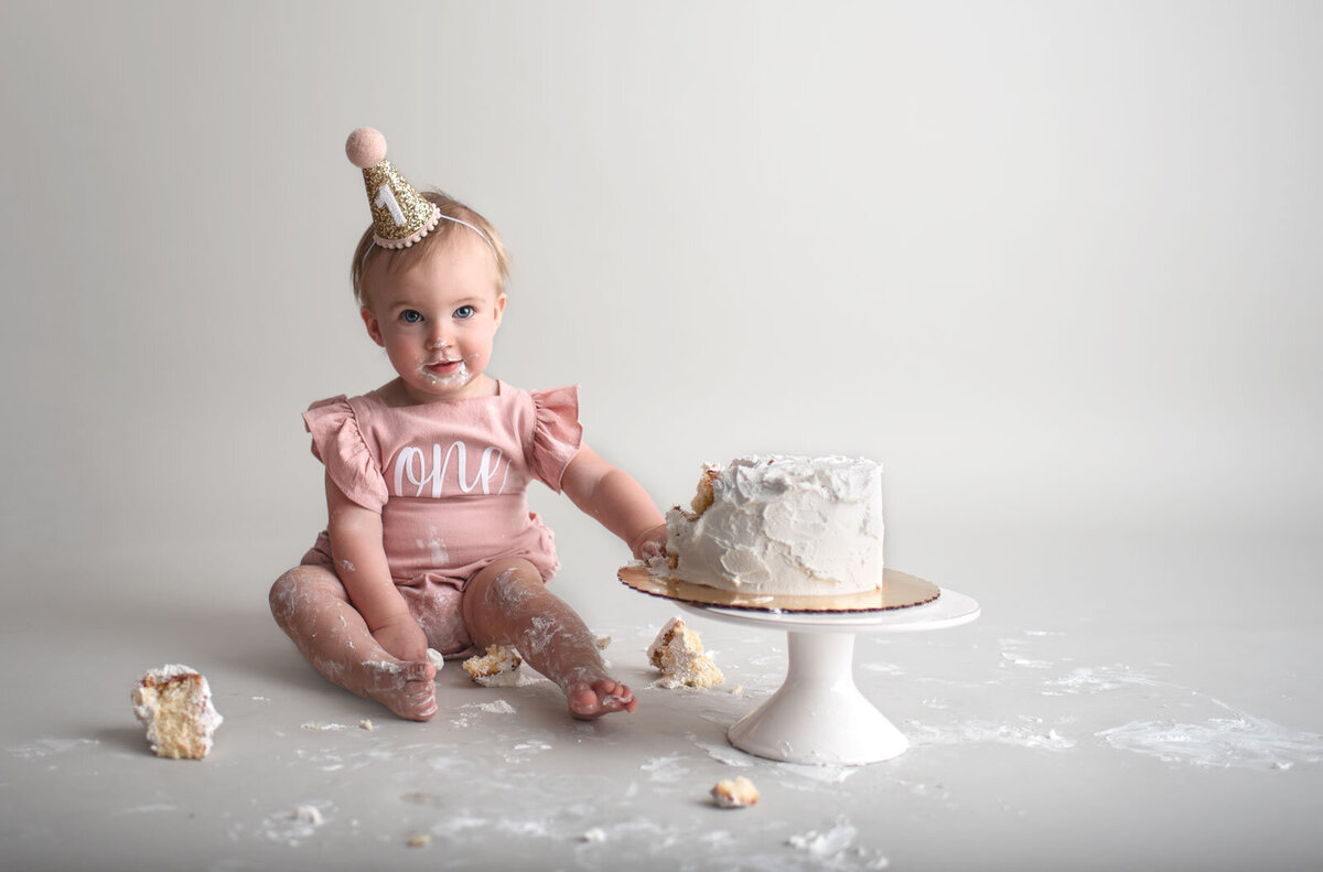 baby smiling next to cake by st. louis cake smash photographer, Sutherland photography