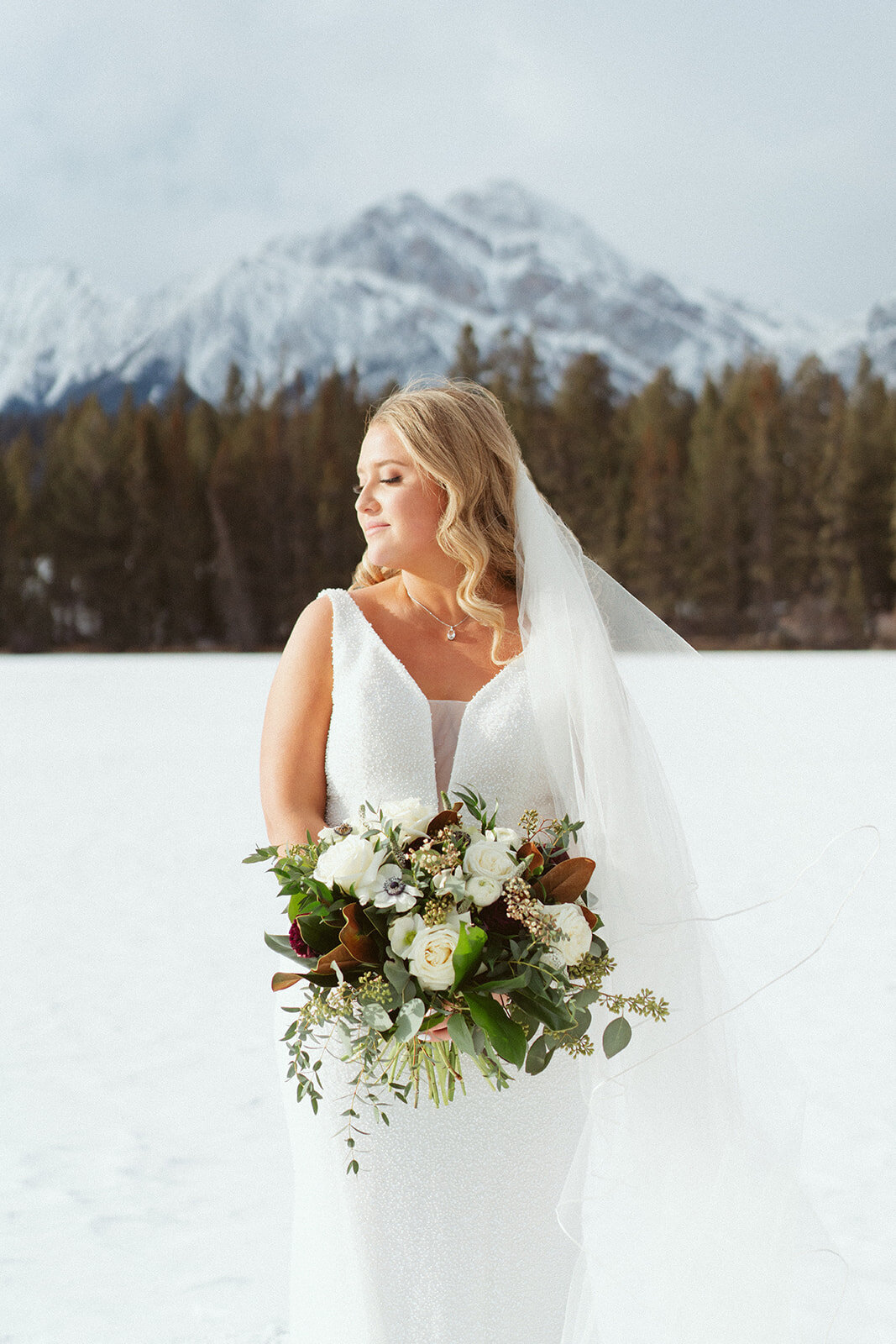 Bride posing outdoors with mountains.