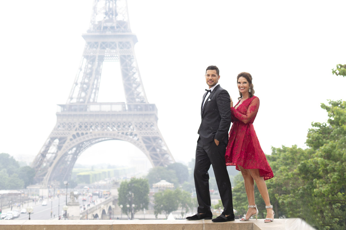 Dressed up couple stand in front of the Eiffel Tower of anniversary photography session in Paris