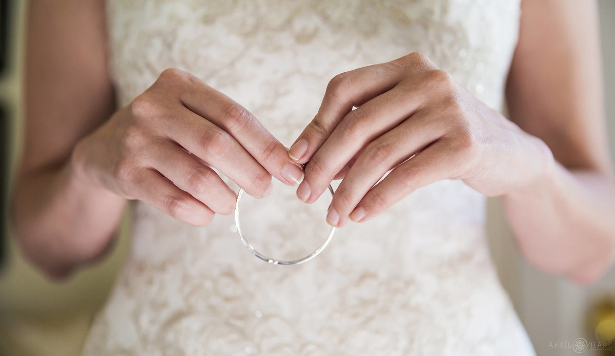 Close up detail photo of bride's hands holding her jewelry in CO