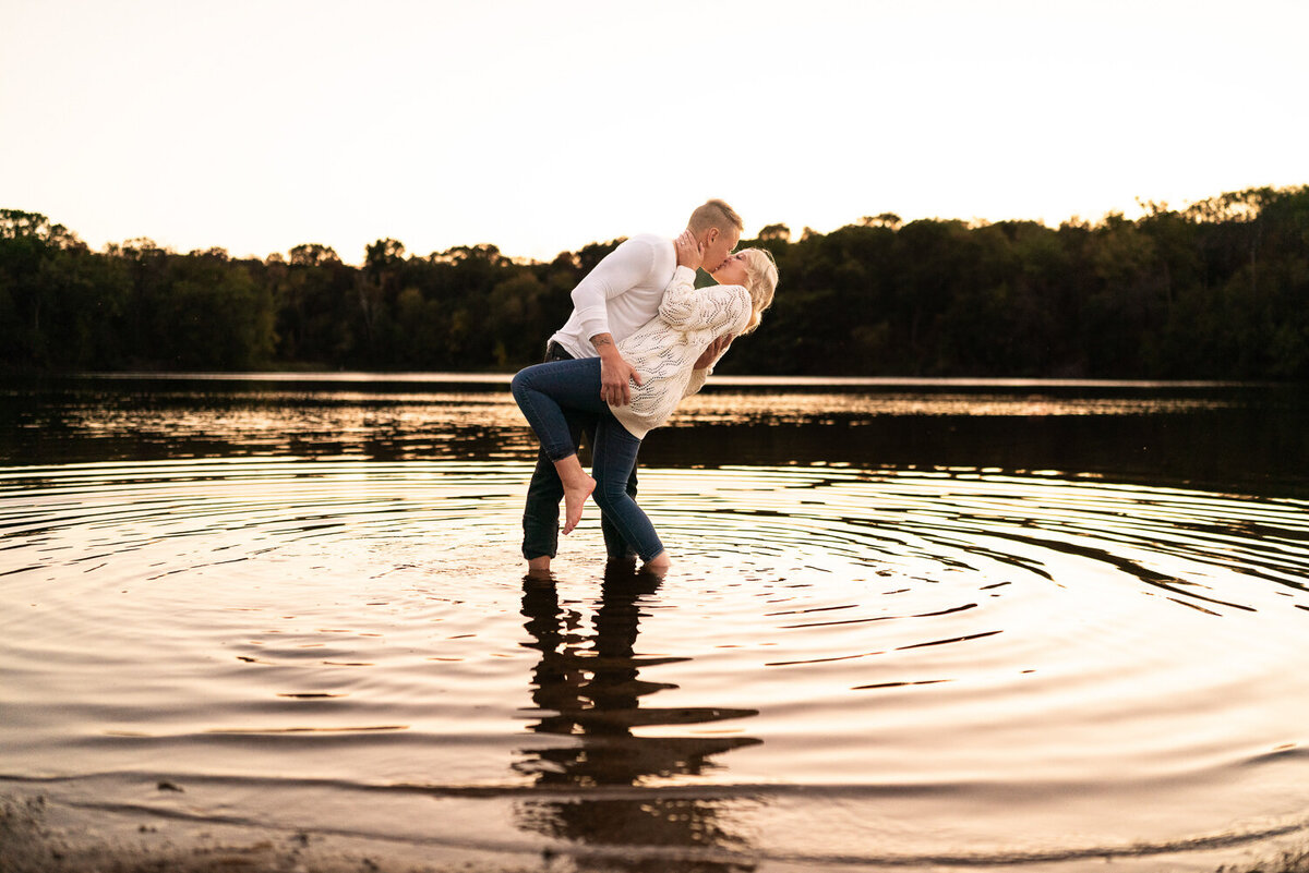 Man and woman kiss in a lake at Sunset in Eagan, Minnesota.