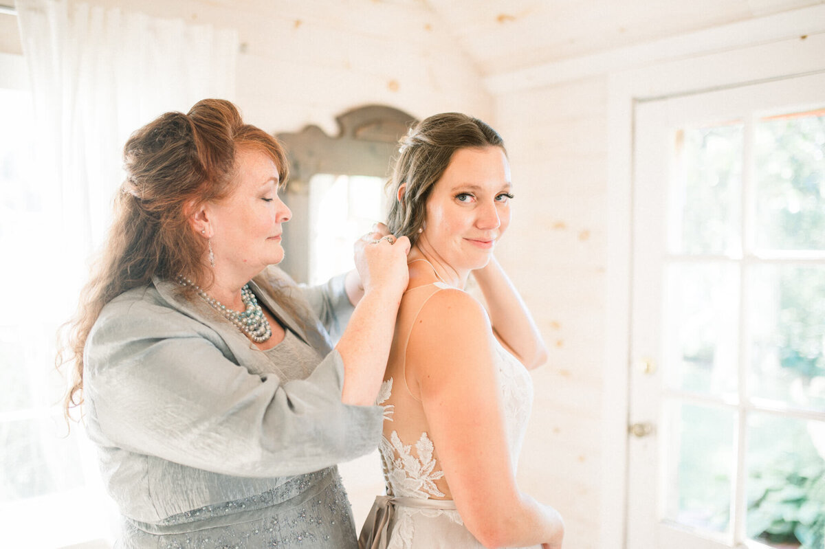 Bride getting help from mom with necklace before her Toronto Wedding