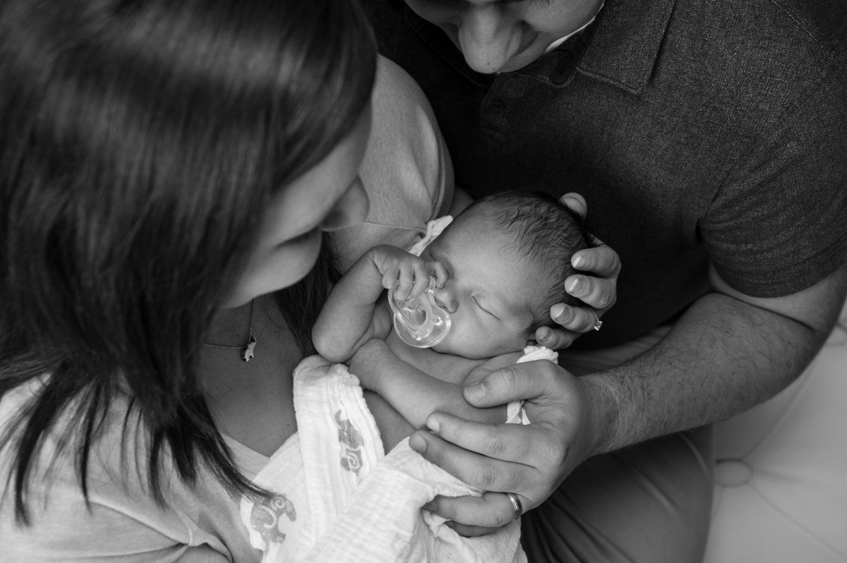newborn black and white photo from above parents holding baby