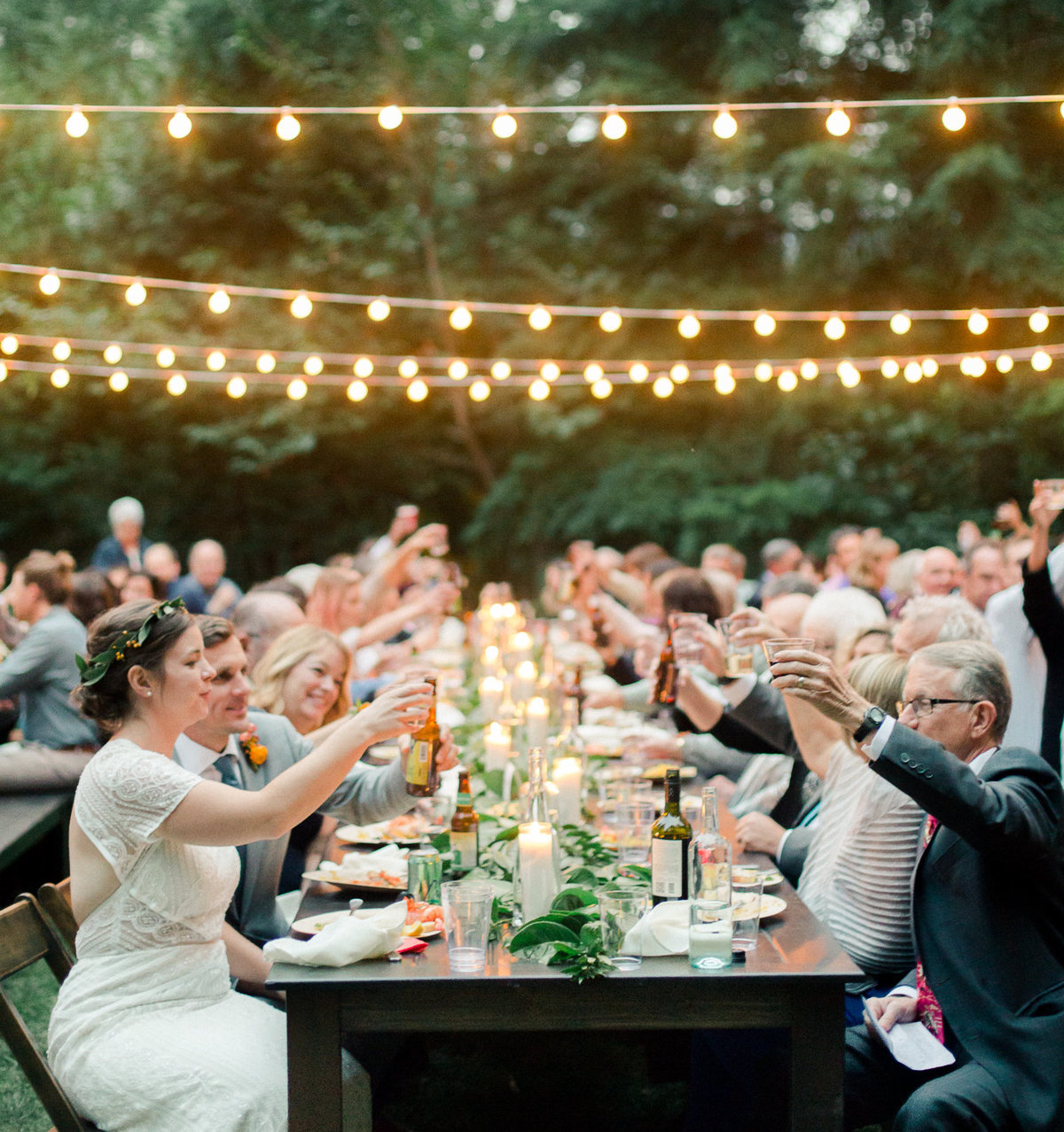cheers of wedding reception table after speeches outdoor wedding under cafe lights wellspring spa washington