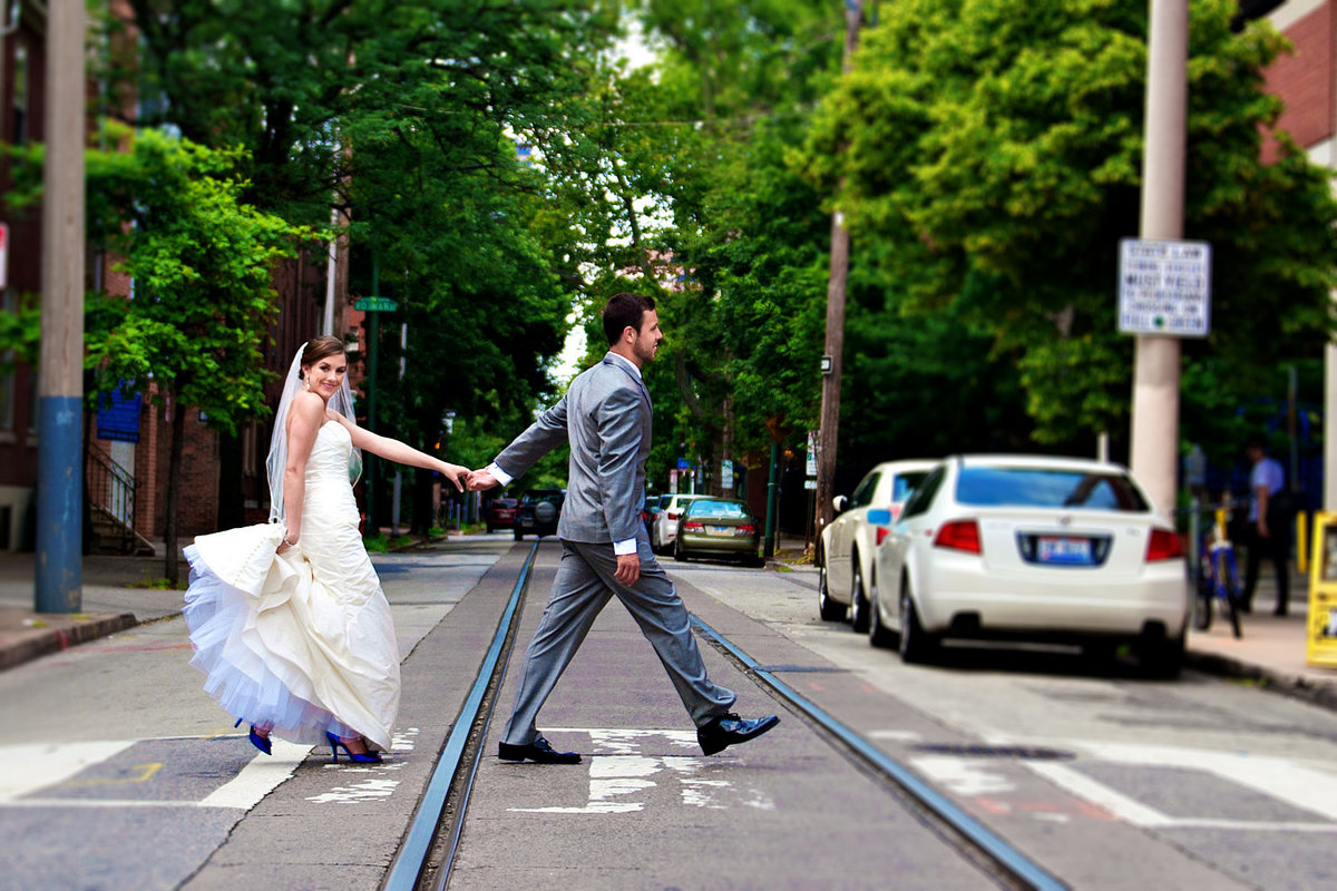 A groom leads his beautiful bride across South Street in Philadelphia