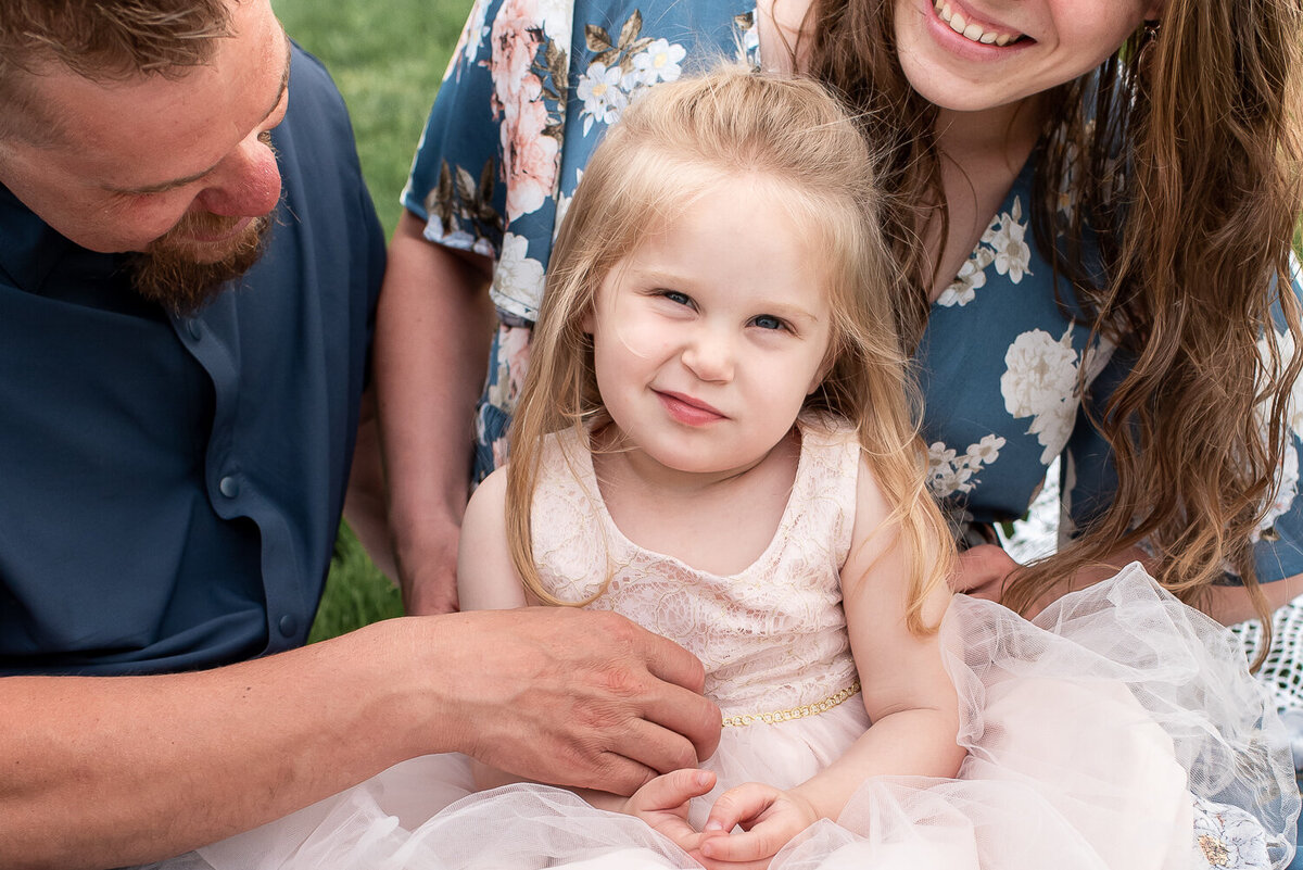 Little girl sitting on parents lap, looking at camera |Sharon Leger Photography | Canton, CT Newborn & Family Photographer
