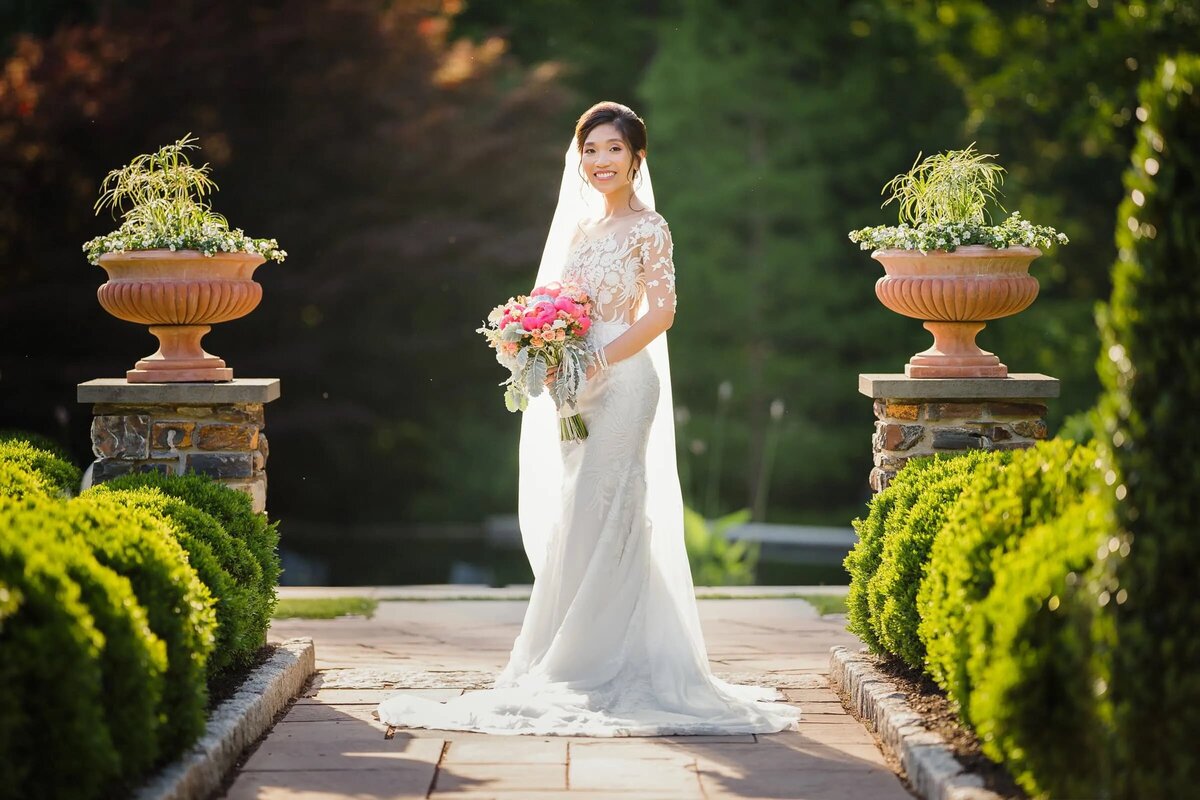 A woman standing on a garden path in a wedding dress