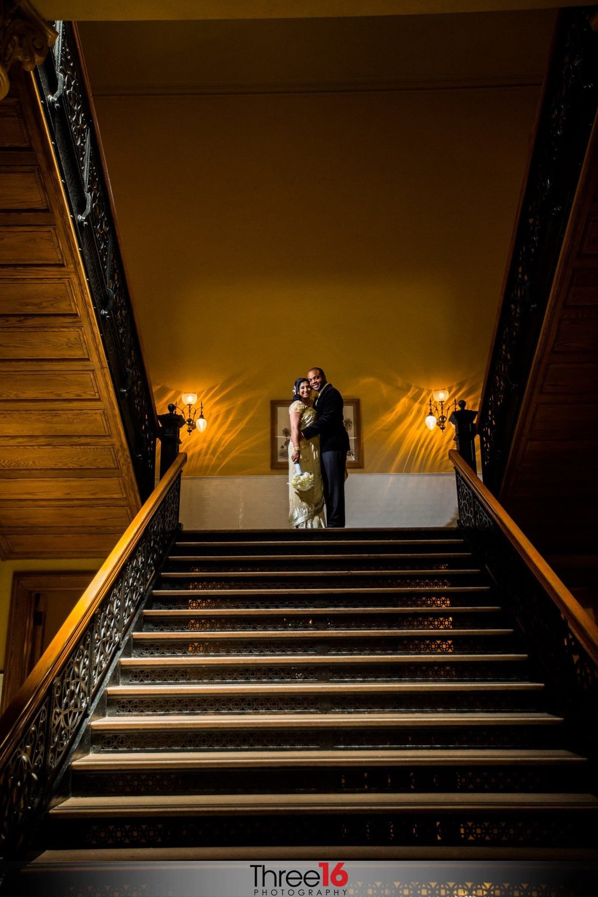 Bride and Groom stand atop of the Old OC Courthouse staircase