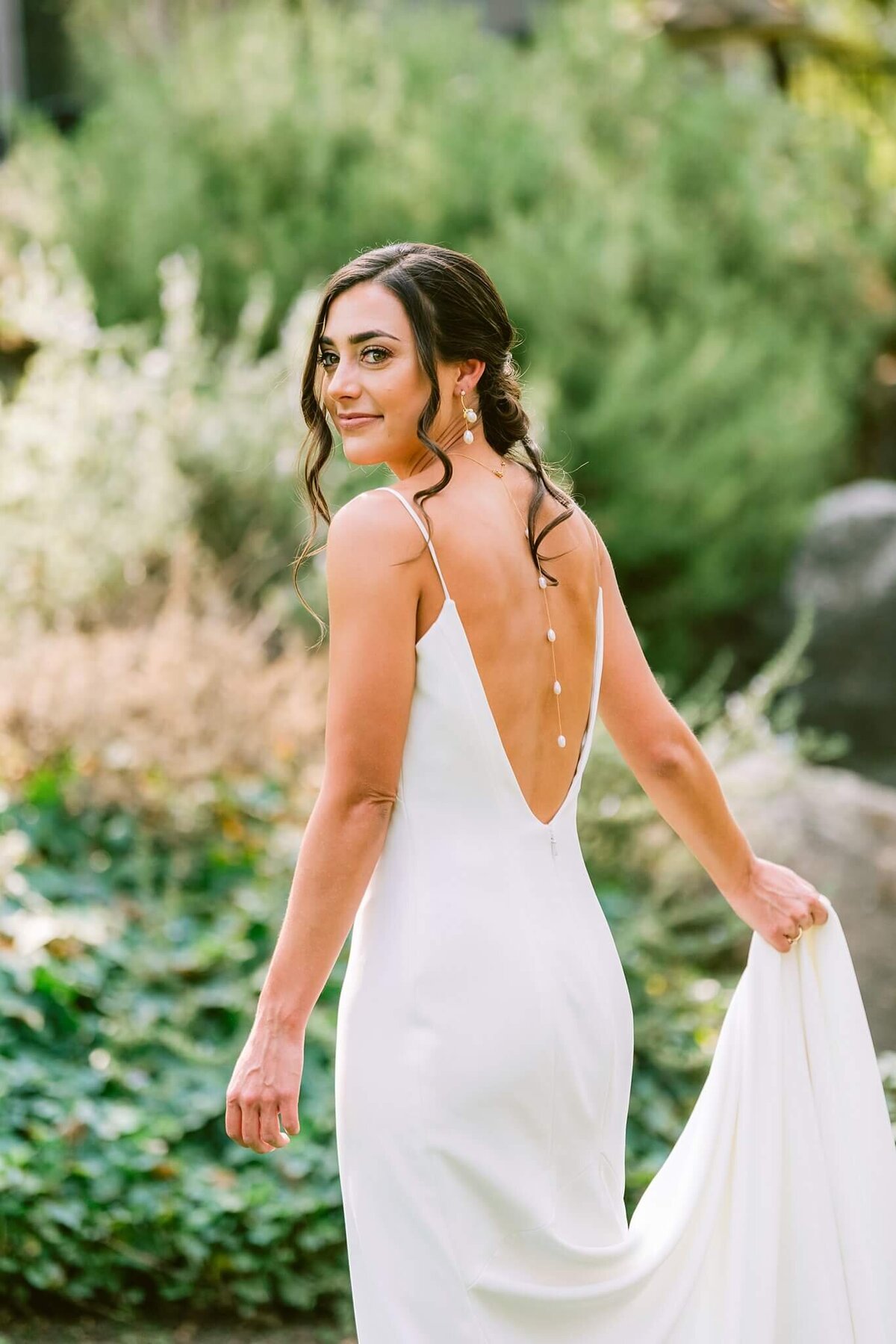 bride portrait over the shoulder holding her dress in the Tahoe foothills