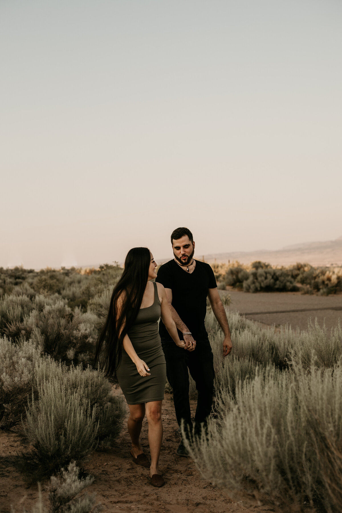engaged couple walking through desert