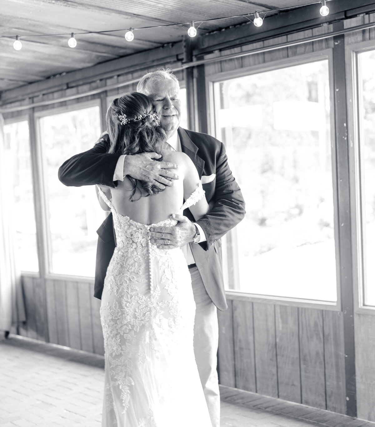 A dad hugging his daughter during a first look on her wedding day enjoying their North Carolina wedding photography