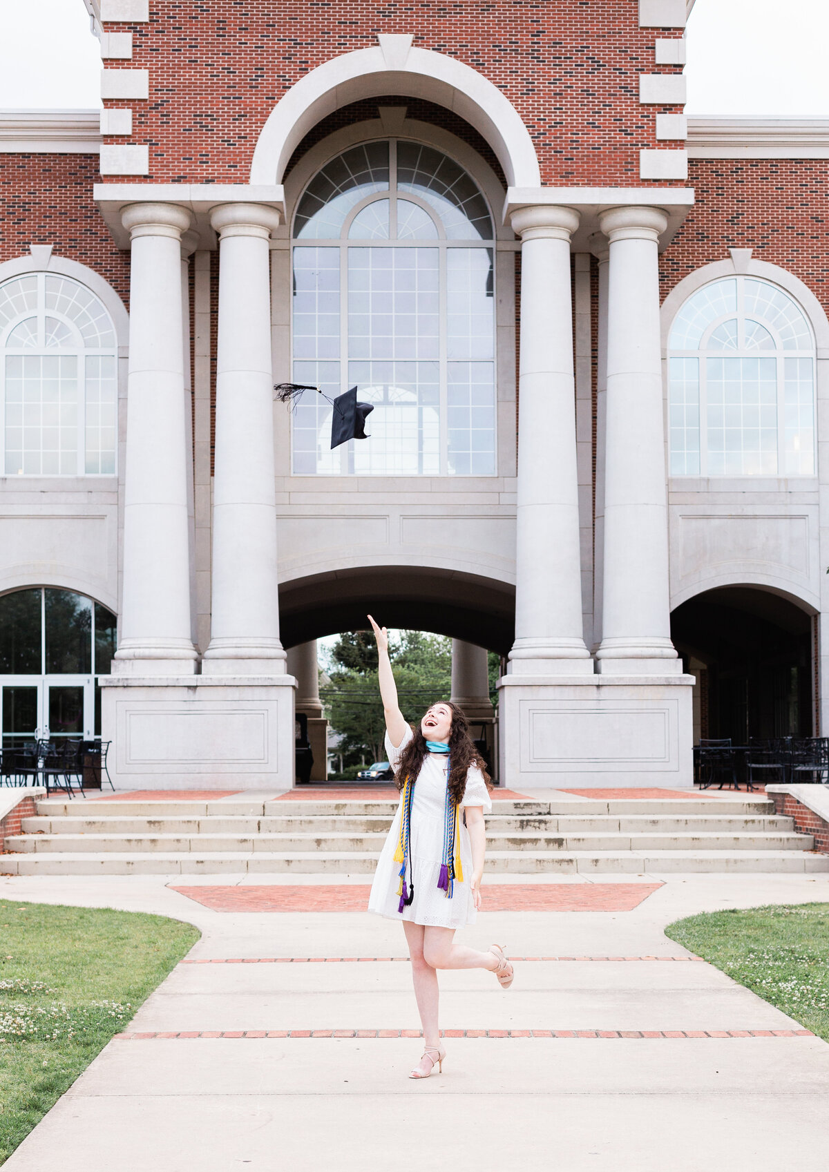 college senior throwing her cap in the air at photo session