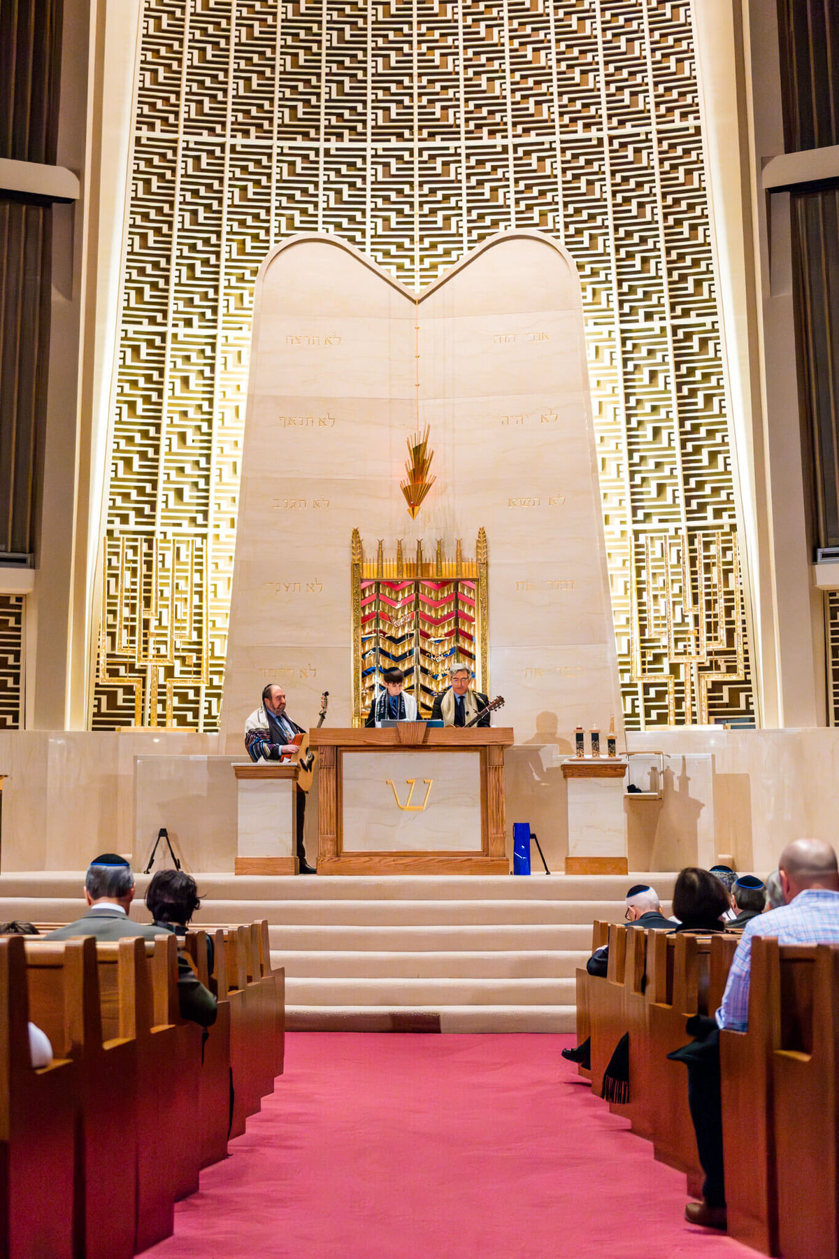 A boy reads from the torah at the bimah during his bar mitzvah