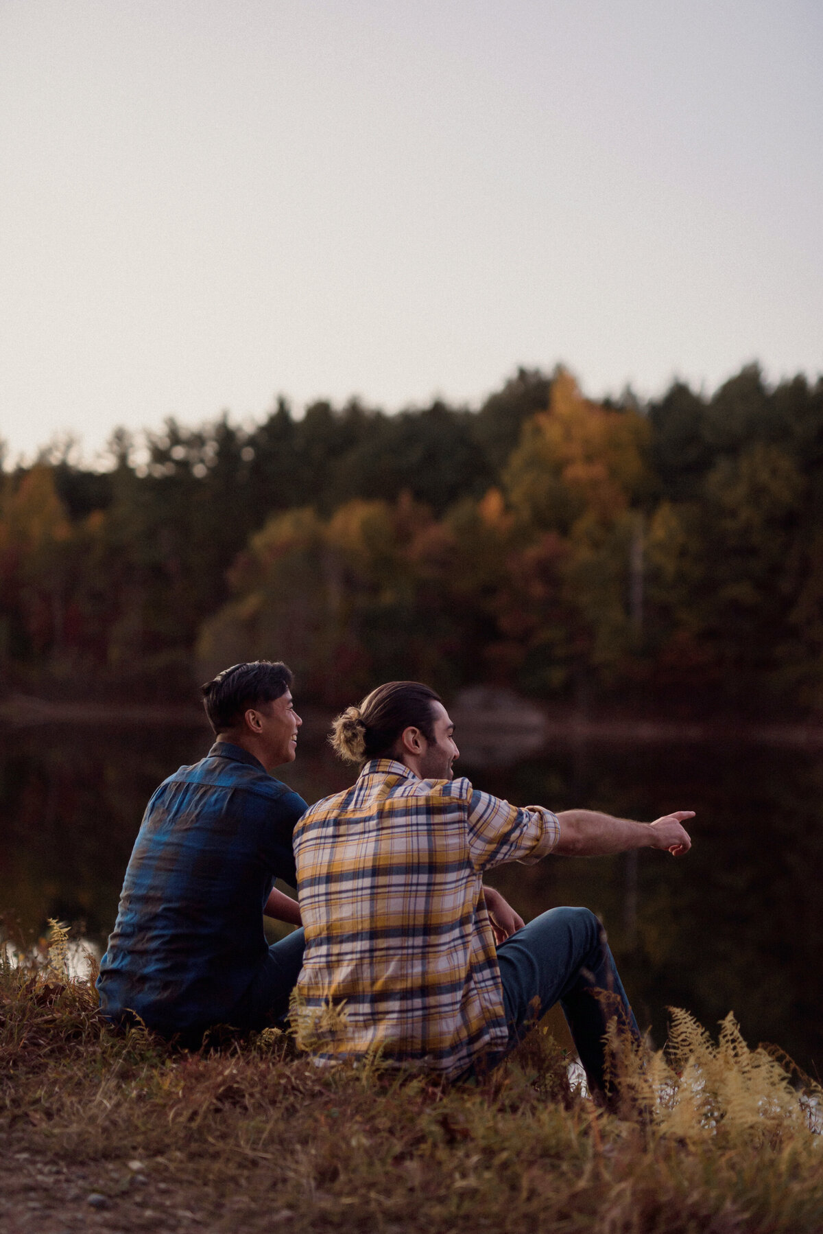 two men engagement session by a lake in the woods. multicultural with a white and asian man. gay couple for a lgbtq  session.